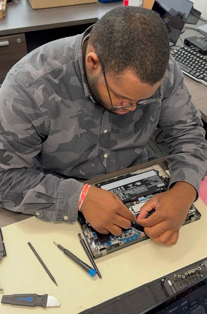 A Princeton Service Center technician repairing the motherboard of an opened business laptop