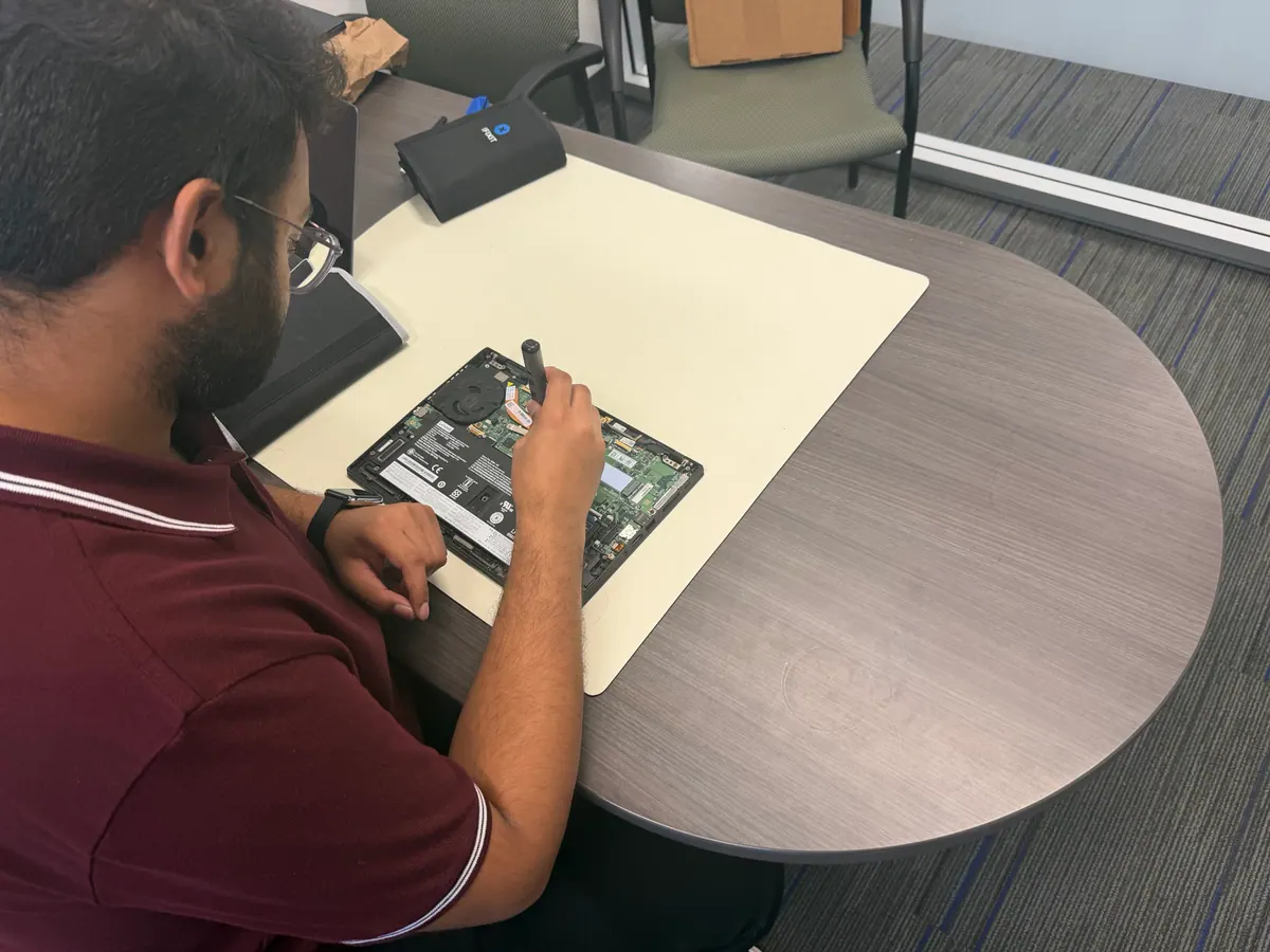 Princeton Service Center technician repairing an opened Lenovo laptop at the repair bench